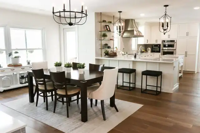 Maitland whole-home remodel with an open kitchen and dining room, black-framed chandeliers, white island seating and wood floors